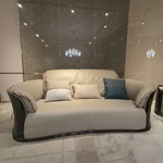 Cream Curved Leather Sofa with Dark Green Fan-Stitched Panels and Laced Edge Details